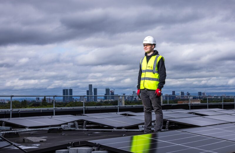 Construction worker on rook with solar panels